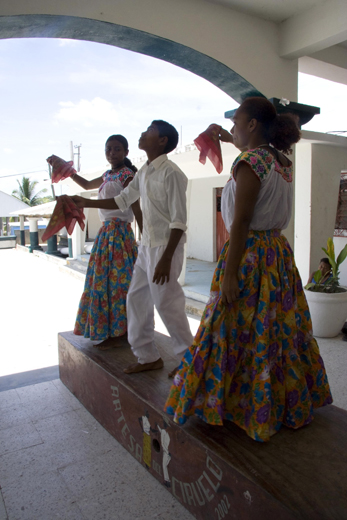 Three youths from the community of El Ciruelo, Oaxaca, perform the baile de artesa, or artesa dance. An artesa is a long, hollow wooden platform upon which barefoot dancers articulate rhythms that accompany the music. Photo by Cristina Díaz-Carrera